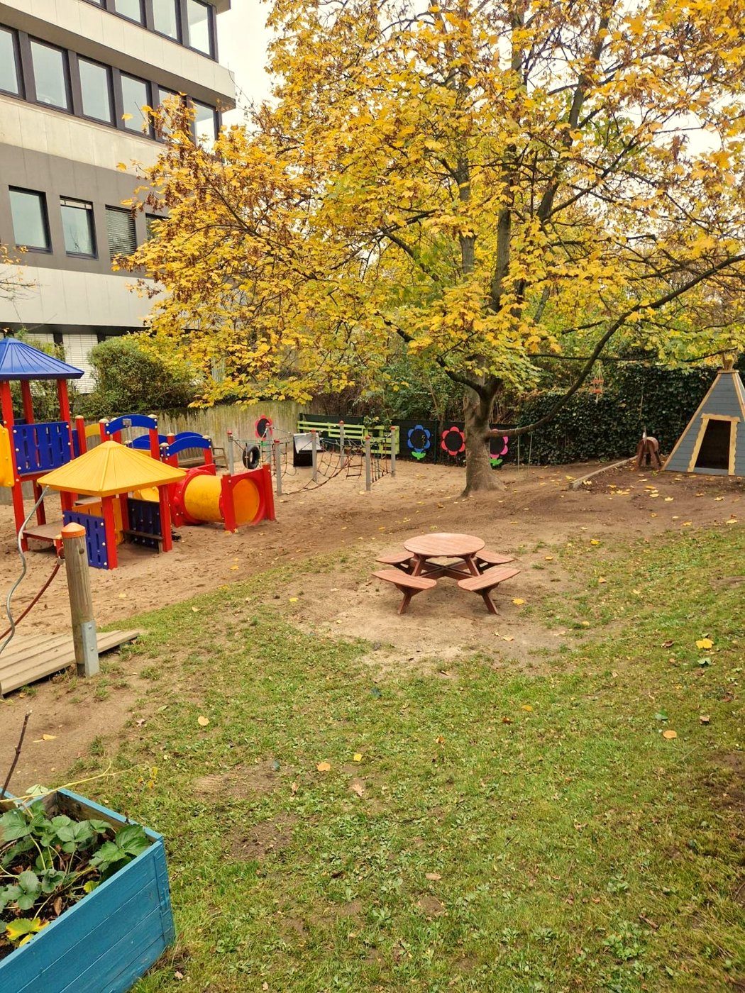 Unser Außengelände im Herbst mit Spielturm und Tipi